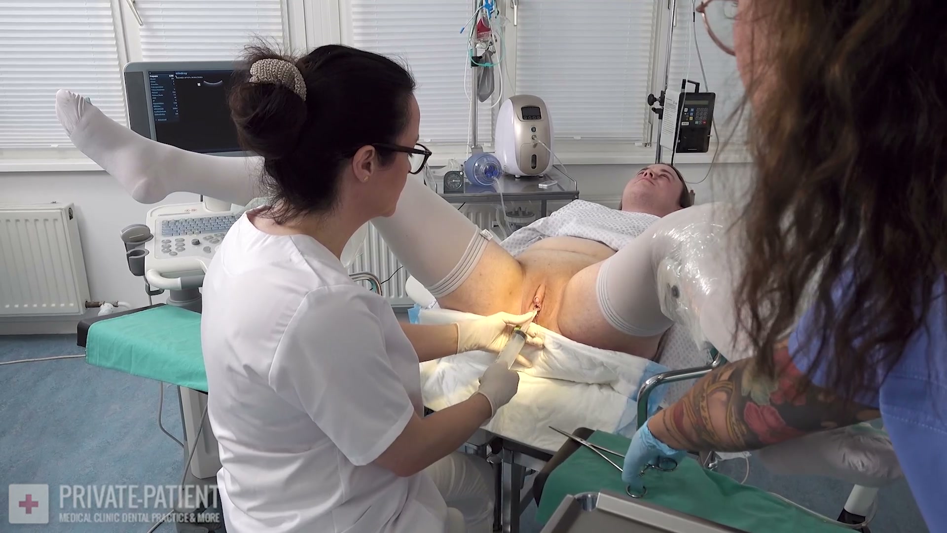 Dr. Eve examining Dr. Lana van Orten as private patient in the free Welcome Dr. Lana part four medical BDSM video from Amara Fetish Clinic Belgium